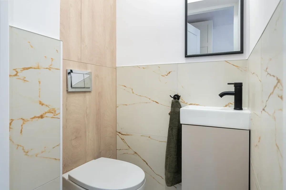 Petite salle de bain avec lavabo mural et toilettes modernes