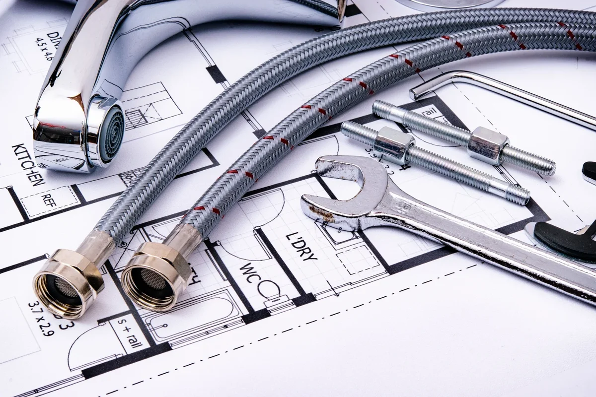 Outils de plomberie disposés sur un plan de travail pour l'installation d'une salle de bains